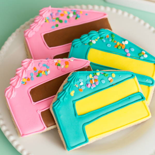 Gourmet birthday cake slice sugar cookies hand-decorated with royal icing and topped with pastel sprinkles.