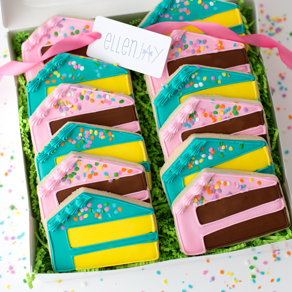 Gourmet birthday cake slice sugar cookies hand-decorated with royal icing and topped with pastel sprinkles.