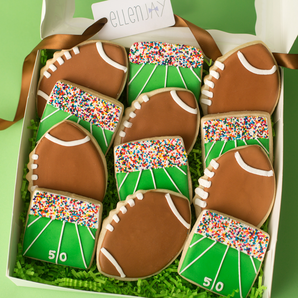 Box of football-shaped cookies with green and brown colors on a green background